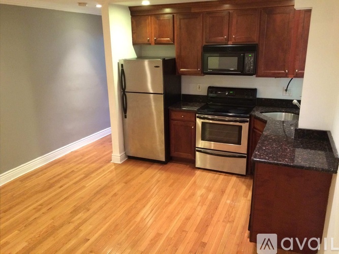 A kitchen with wooden cabinets and a stainless steel refrigerator.