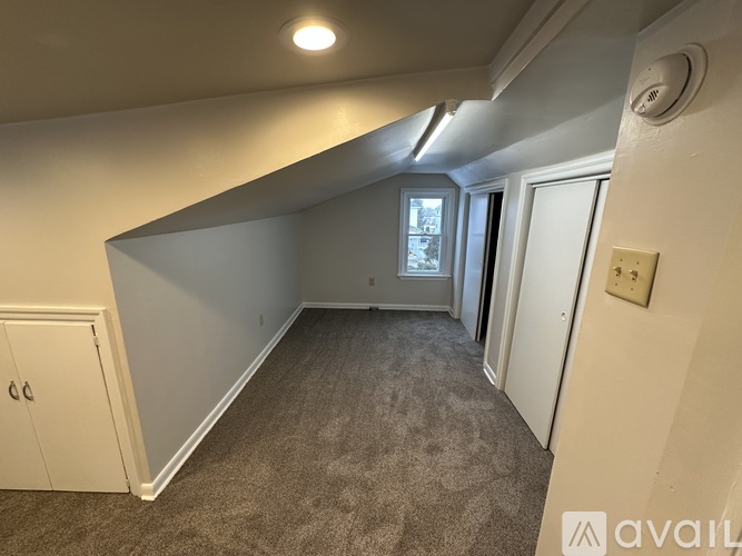 A room with a carpeted floor and a window.