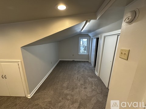 A room with a carpeted floor and a window.