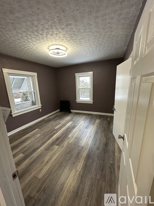 A room with brown walls and wooden flooring.