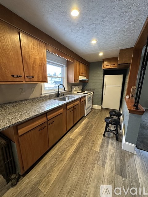 A kitchen with wooden cabinets and a white refrigerator.