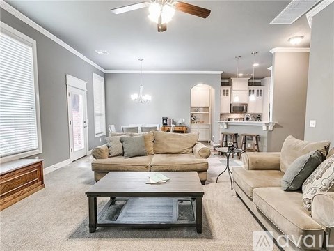 A living room with a brown couch and a coffee table in the center.
