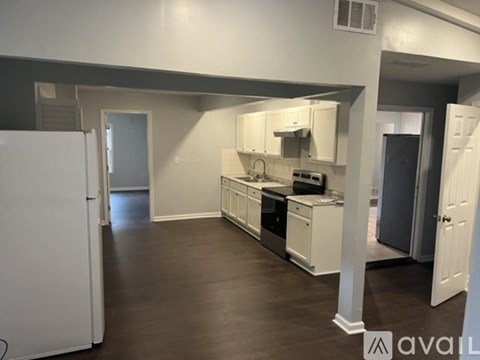 A kitchen with white cabinets and a white refrigerator.