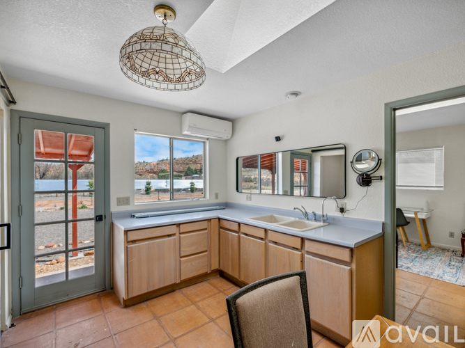 A kitchen with wooden cabinets and a large window overlooking a field.