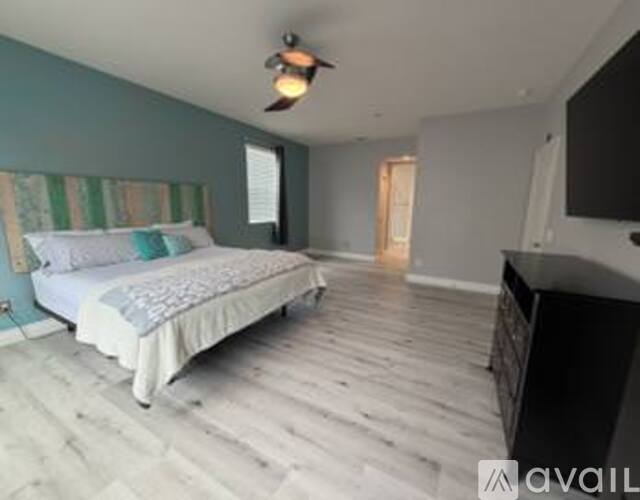 A bedroom with a bed, dresser, and television.
