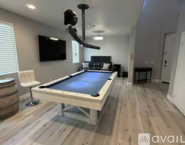 A pool table in a room with a television and a barrel.