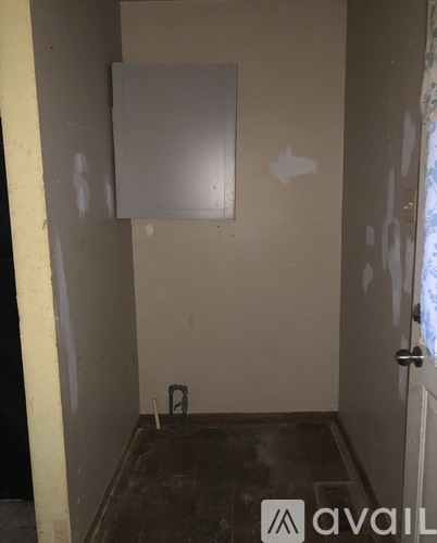 A room with a wall-mounted electrical panel and a door.