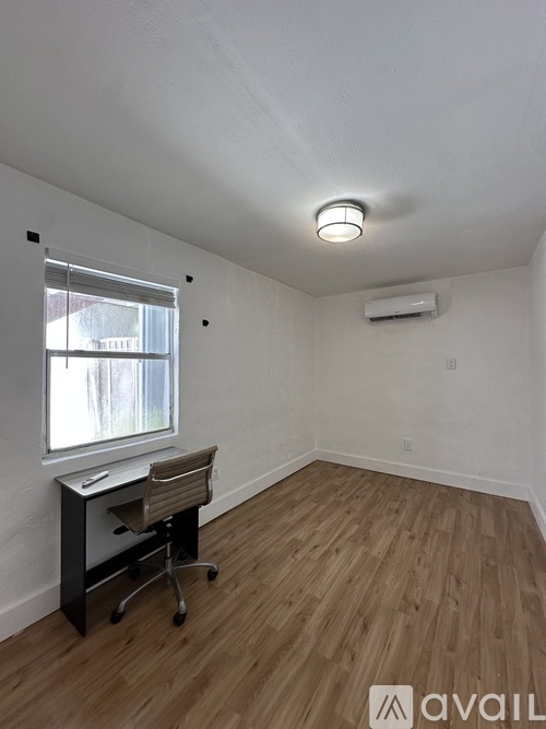 A room with a desk and chair in it.
