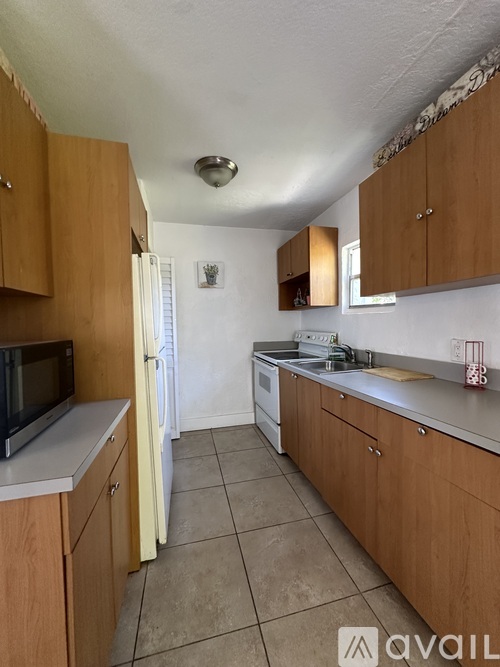 A kitchen with wooden cabinets and a white refrigerator.