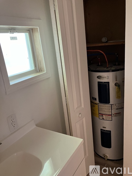A white bathroom with a toilet and a window.