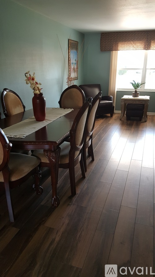 A dining room with a table and chairs.