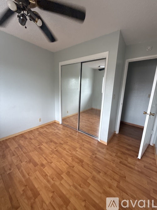 A room with wooden floors and a ceiling fan.