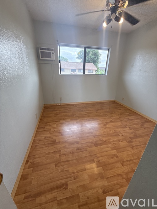 A room with wooden flooring and a ceiling fan.