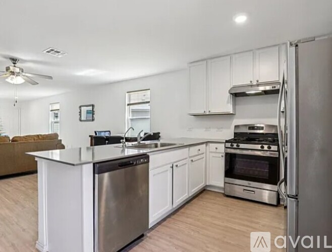 A modern kitchen with stainless steel appliances and white cabinets.