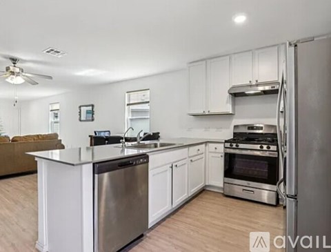 A modern kitchen with stainless steel appliances and white cabinets.