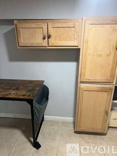 A wooden table with a chair and a cabinet are in the image.