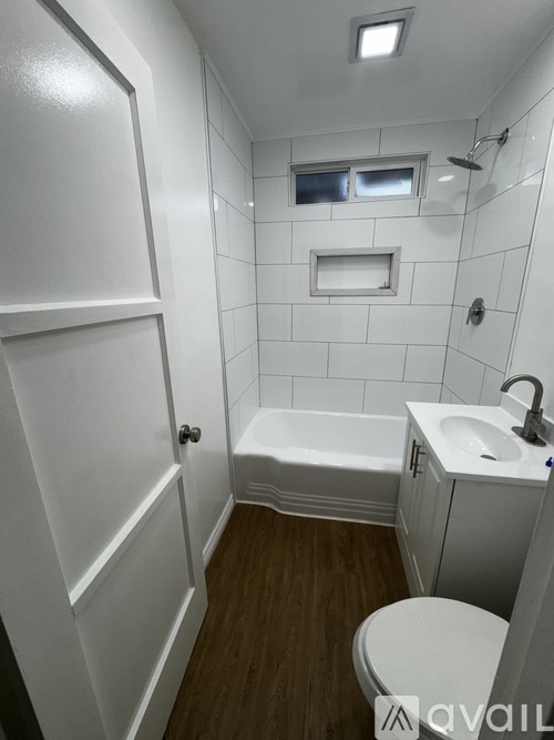 A white bathroom with a toilet, sink, and bathtub.