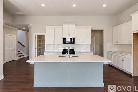 A kitchen with a large island and white cabinets.