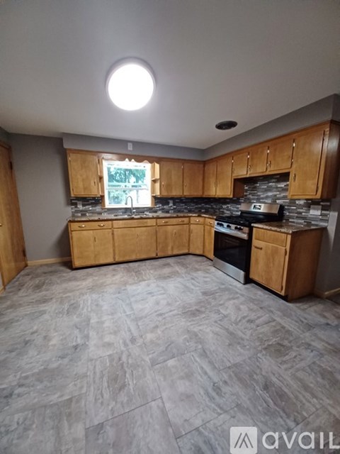A kitchen with wooden cabinets and a stone countertop is available for rent.