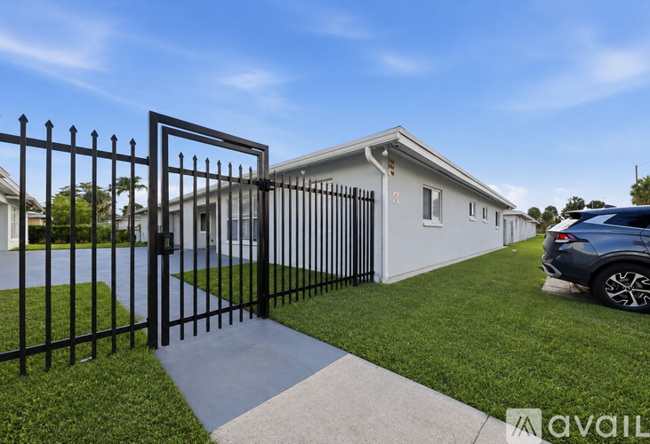 A house with a black gate and a car parked in front.