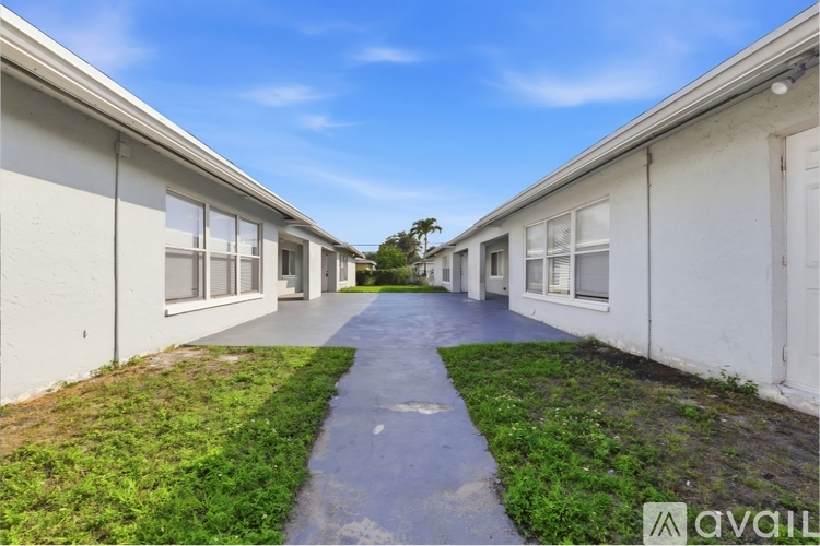 A long pathway leads between two rows of white houses.