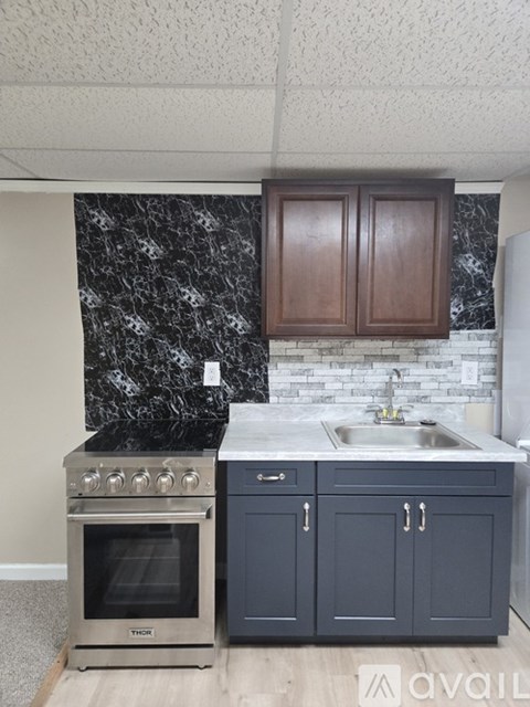 A kitchen with a stove top oven and a sink.