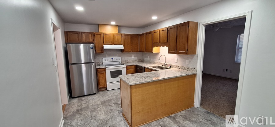 A kitchen with a refrigerator, oven, and sink.