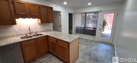 A kitchen with wooden cabinets and granite countertops.