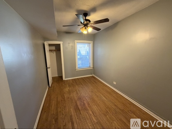 A room with a ceiling fan and wooden flooring.
