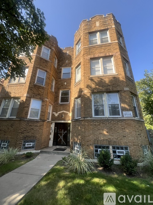 A tall brick building with a black door and windows on the second floor.