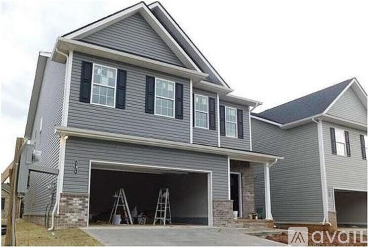 A two-story house with a garage and a brick wall.