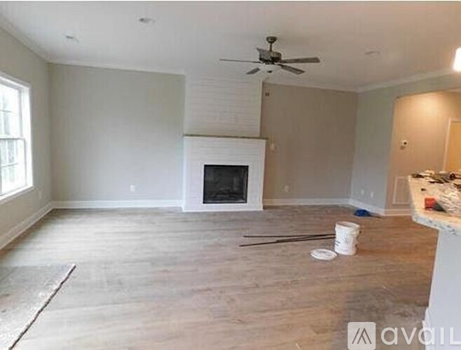 A room with a fireplace and a fan on the ceiling.