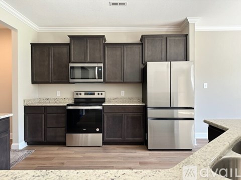 A kitchen with dark brown cabinets and stainless steel appliances.