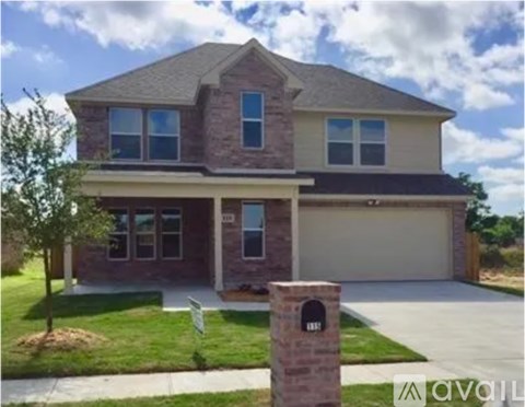 A house with a garage and a brick pillar in front.