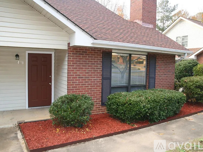 A house with a red door and a brick wall.