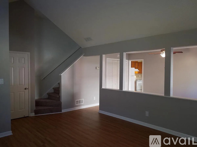 A spacious room with a staircase and a window.