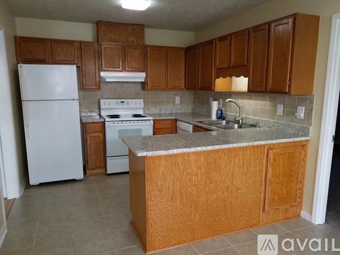 A kitchen with wooden cabinets and a white refrigerator.