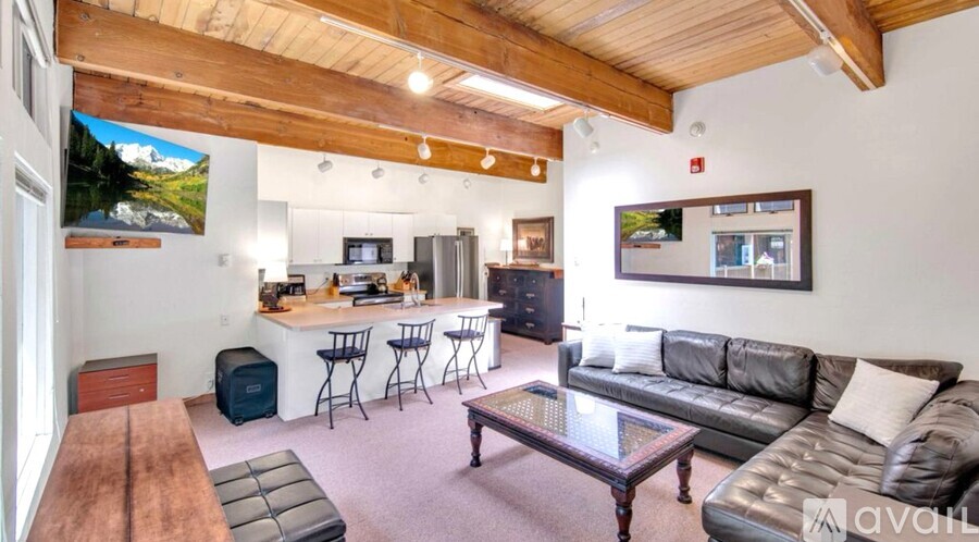 A living room with a couch, a coffee table, and a bar area.