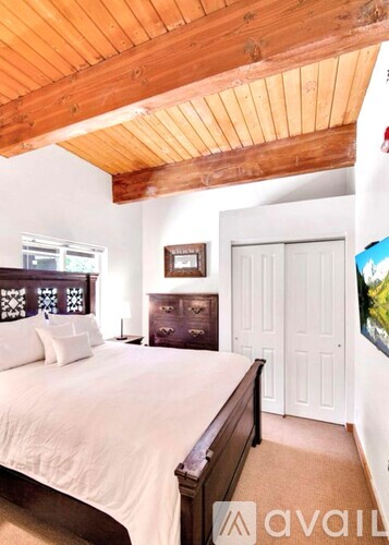 A bedroom with a bed, dresser, and a painting on the wall.