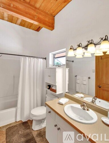 A bathroom with a toilet, sink, and mirror.