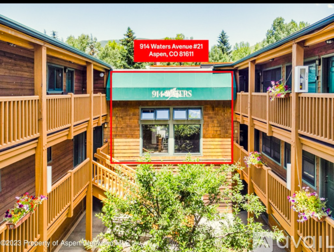 A wooden building with a green awning and a sign that reads "914 Waters Avenue #21 Aspen CO 81611".