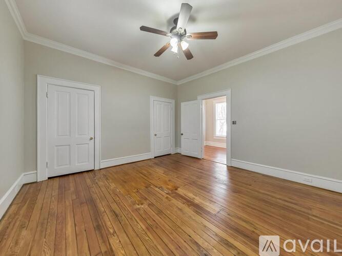 A room with wooden floors and a ceiling fan.