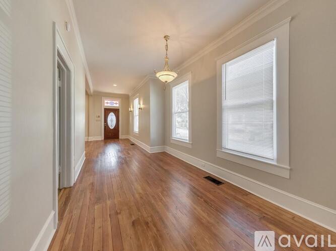A long hallway with wooden floors and white walls.