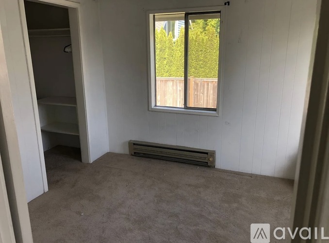 A room with a window and a radiator on the floor.