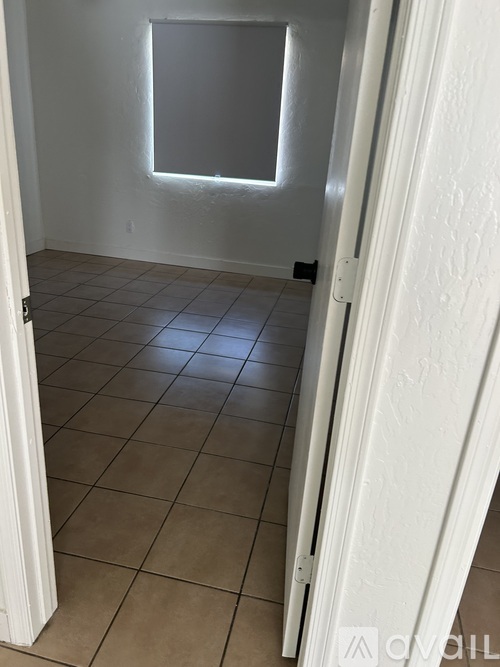 A room with a tiled floor and a window.