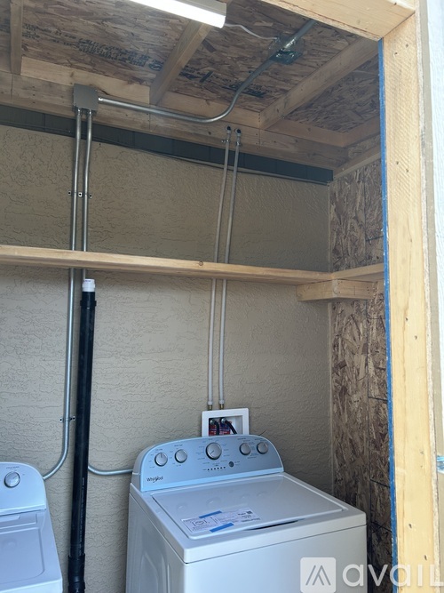 A washer and dryer in a small room with wood paneling.