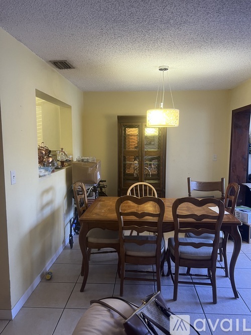 A dining room with a wooden table and chairs.