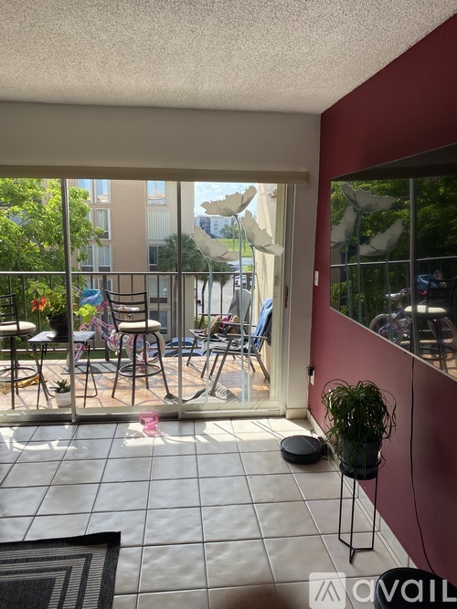 A balcony with a table and chairs overlooking a building.