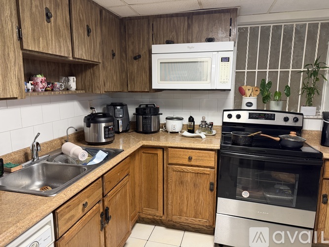 A kitchen with wooden cabinets and a stove top oven.