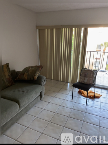 A living room with a grey couch and a chair.
